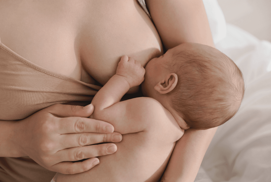 Mutter im Wochenbett stillt ihr Baby, Doula Begleitung
